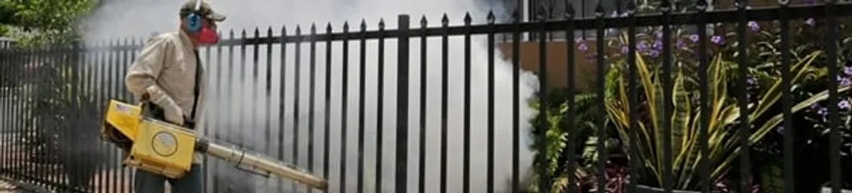 Mosquito control technician fogging a yard perimeter for mosquito reduction in Rockford, IL